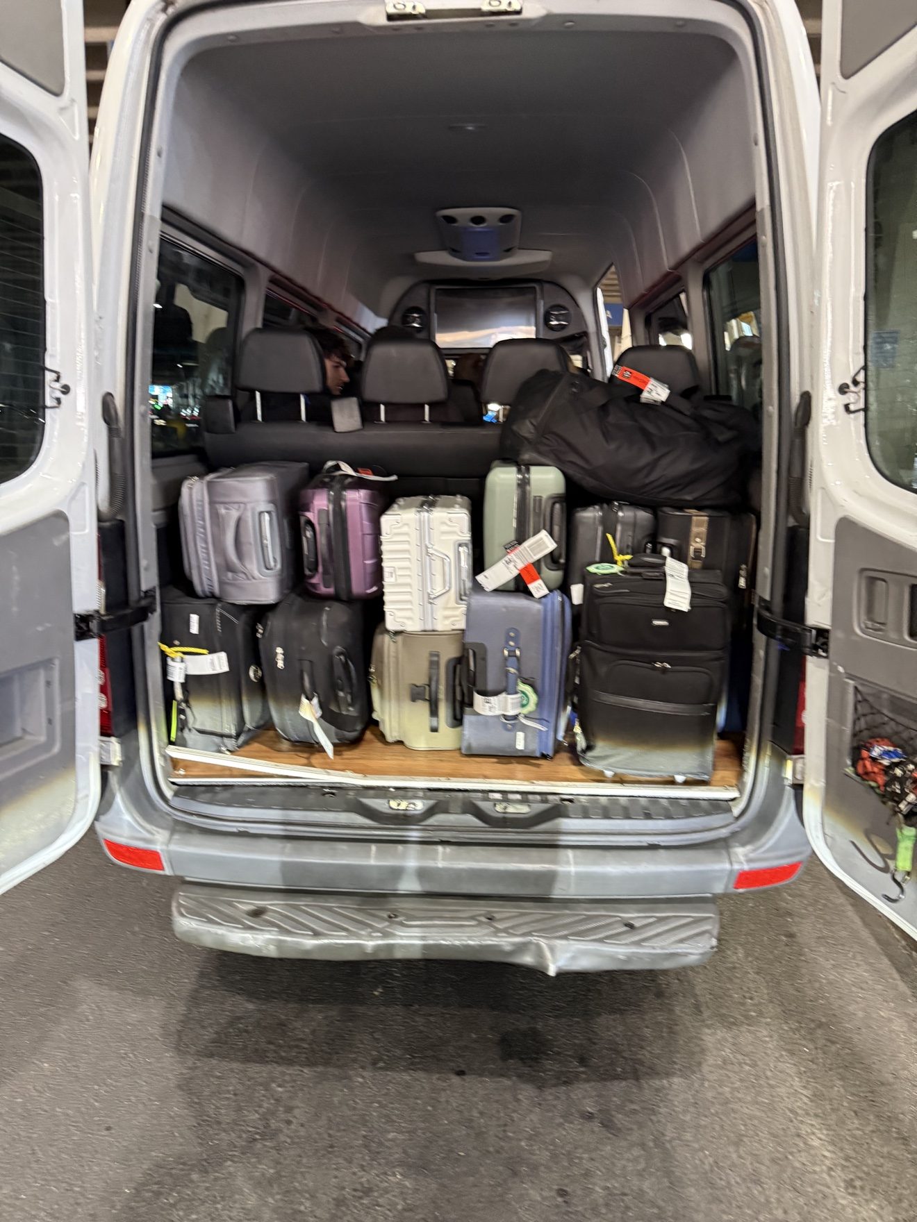 Loading luggage into a Sprinter van for an airport transfer