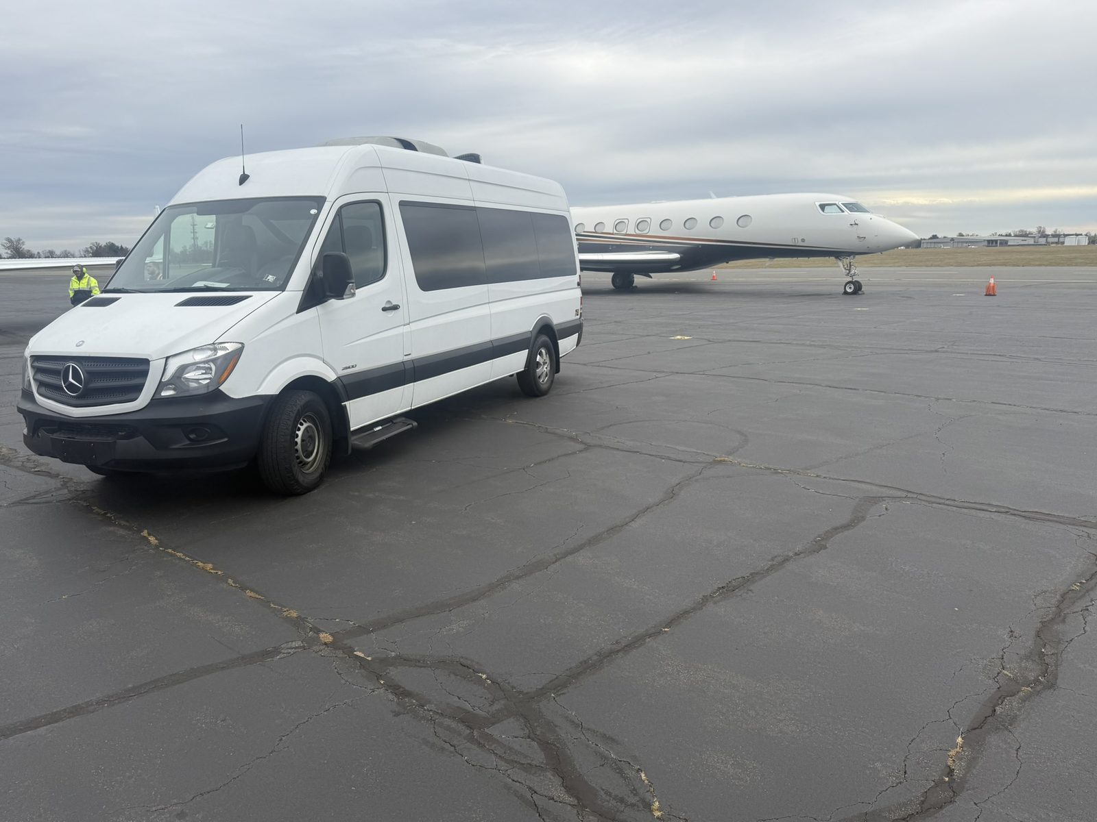 Sprinter van beside a private jet at an FBO